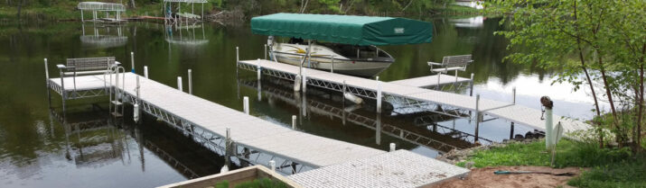 view from shoreline of dock with bend and boat lift installed with canopy