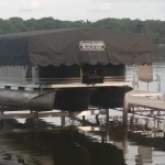 Boat lifted out of water with boat lift covered with black canopy